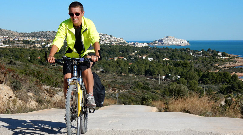 Amelia in bicicletta sullo sfondo di Peniscola