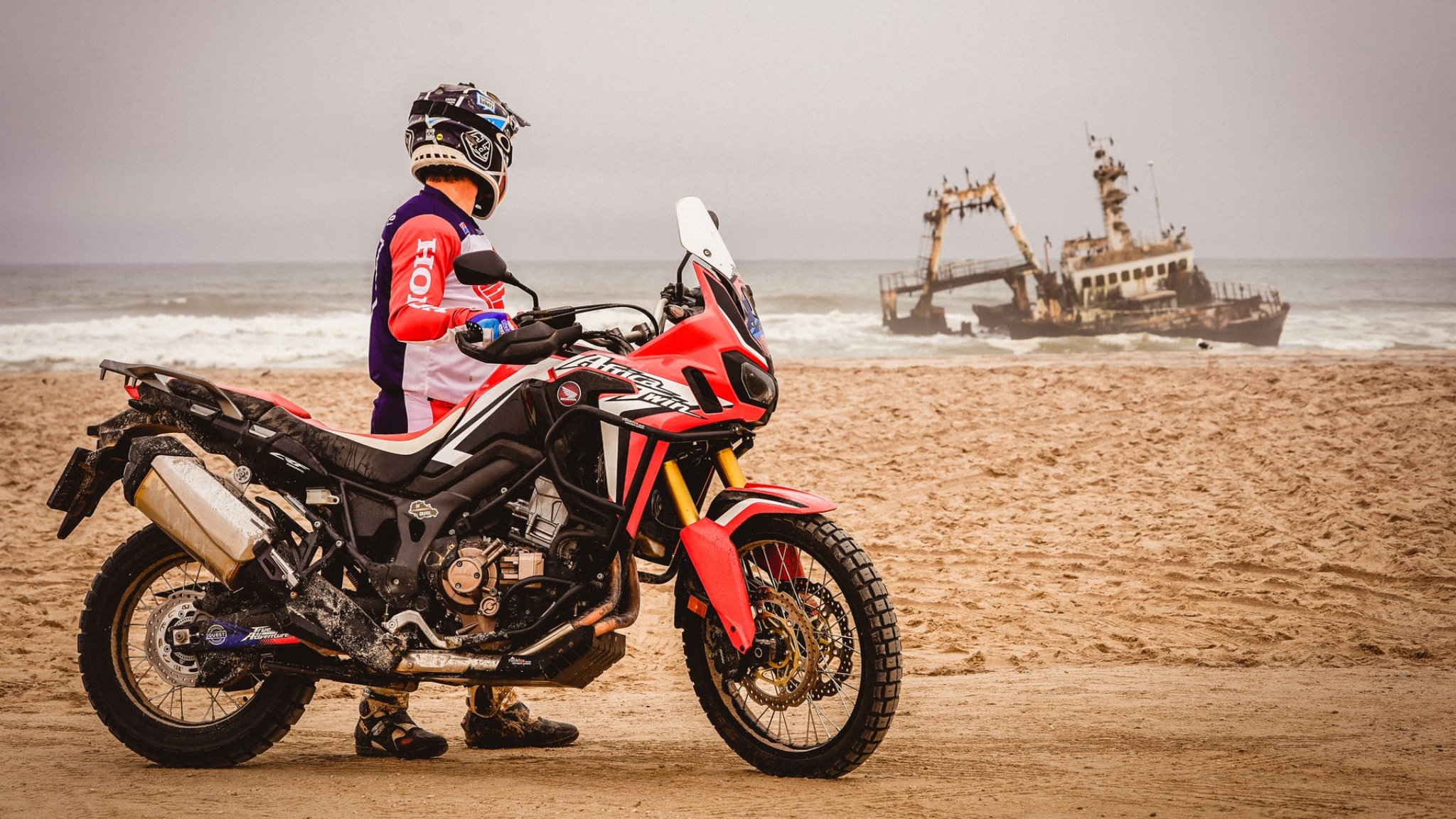 Un motociclista osserva un relitto lungo la Skeleton Coast