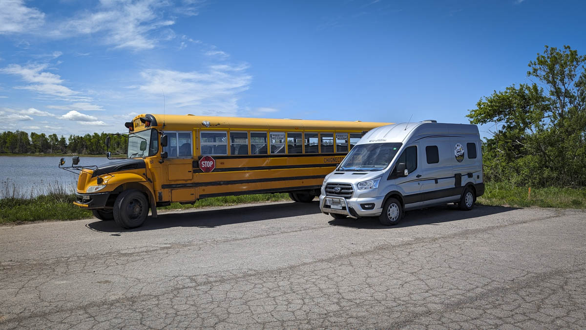 Ford Transit van parcheggiato di fianco ad uno schoolbus americano